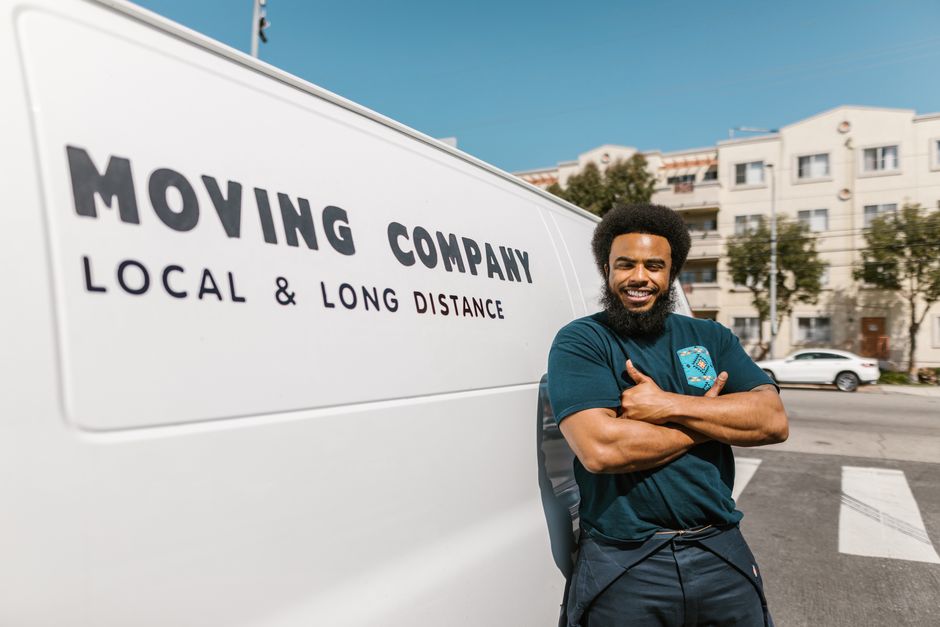Professional moving team smiling and coordinating boxes in a driveway